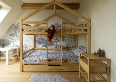 jasny pokój dziecięcy z piętrowym łóżkiem z drewna w kształcie domku