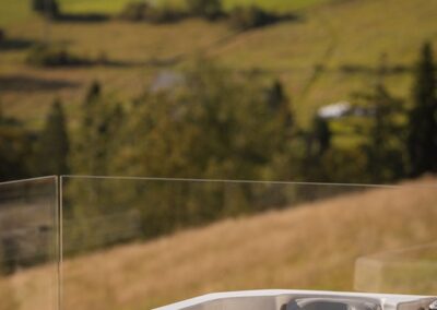 jacuzzi na tarasie z widokiem na zielone pola i góry