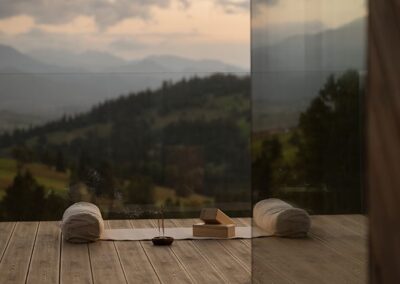 widok na taras z rozwiniętą matą do jogi. W tle zachód słońca na górami